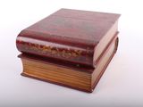 two books stacked on top of each other on a white surface