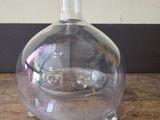 a clear glass vase with a clear base on a wooden table