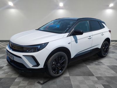 un 4x4 blanc garé sur un sol en damier dans un garage