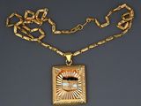 an image of a gold necklace with a square pendant with a diamond in the center