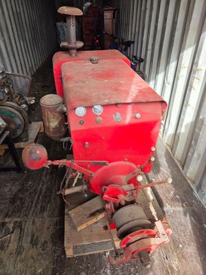 un tracteur rouge qui se trouve à l'arrière d'un camion