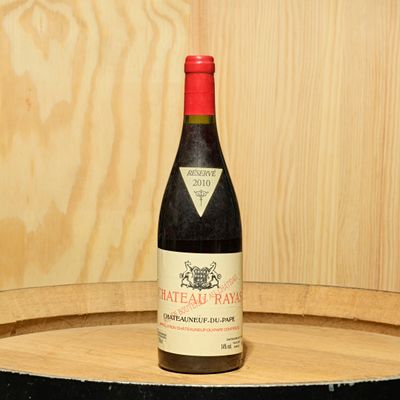 une bouteille de vin posée sur un tonneau en bois