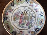 three plates with asian designs on them sitting on a wooden table