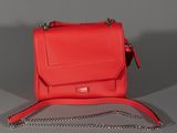 the small red bag is sitting on the table with a chain around it