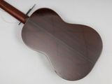 a close up of an acoustic guitar on a white surface