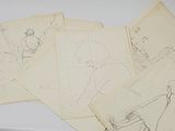 a pile of drawings on a table next to a cup of coffee