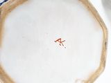 a white plate with a red line on it next to a cup