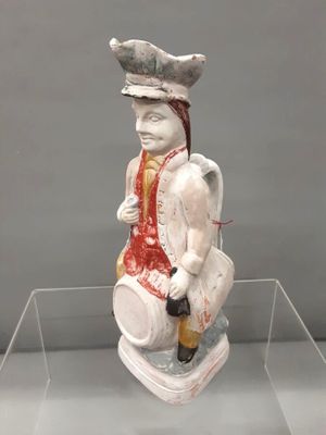 une statue représentant un homme assis sur un tabouret