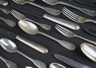 a lot of silver spoons and forks on a table