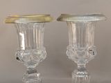 pair of clear glass vases with gold rims sitting on a table