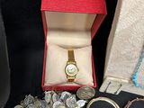 a box with a watch, bracelets, and other jewelry on a table