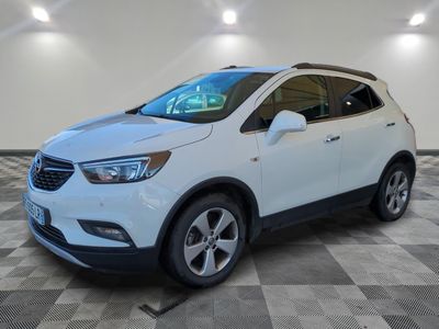 Un SUV Buick blanc est garé dans une grande pièce