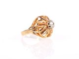 a close up of a gold and diamond ring on a white surface