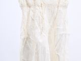 the top of a white dress hanging on a clothes rack