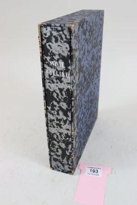 un vieux livre posé sur une table blanche, à côté d'une étiquette rose