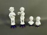 three figurines of a boy and a girl with a flute