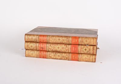 trois vieux livres empilés sur une surface blanche