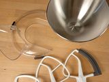 a metal bowl and a pair of ear buds on a table