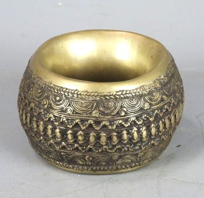 an old brass bowl on a white surface with a white background