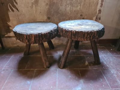 two wooden stools sitting next to each other on a tiled floor