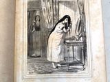 un vieux livre sur lequel figure l'image d'une femme debout devant un miroir