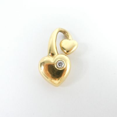 une image représentant un pendentif en forme de cœur en or, orné d'un diamant au centre