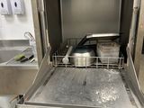 a dishwasher in the middle of a stainless steel counter
