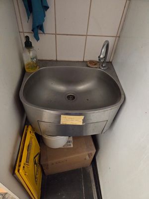 a sink in the corner of a small bathroom