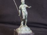 bronze statue of a man holding a spear on a marble base