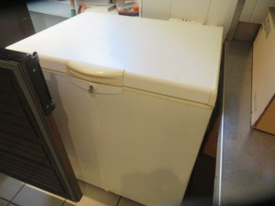 a white refrigerator sitting in the corner of a kitchen