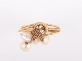 une image représentant une bague en or ornée de perles sur fond blanc