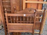 a bed with a wooden headboard and a wooden chair next to it
