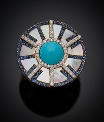 une bague blanche et bleue sertie d'une pierre turquoise entourée de diamants bleus et blancs