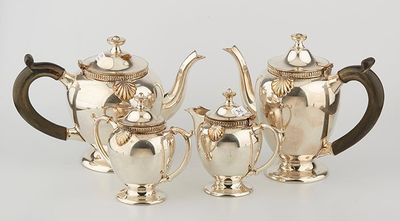 three pieces of silver tea and coffee set on a white surface