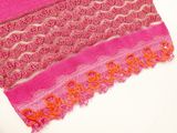 a close up of a pink scarf on a white chair