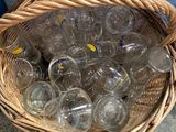 a basket full of empty glasses sitting on the ground