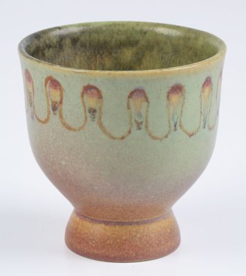 a green and brown bowl on a white surface