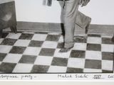 a black and white photo of a man standing in front of a television