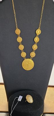 un gros plan d'un collier et d'une boucle d'oreille sur un mannequin