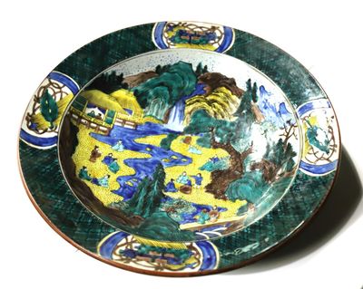 a plate with a painting on it sitting on a table