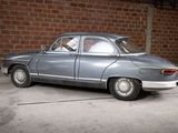a silver car parked in front of a brick wall