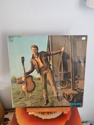 une vieille photo d'un homme tenant une guitare posée sur une table