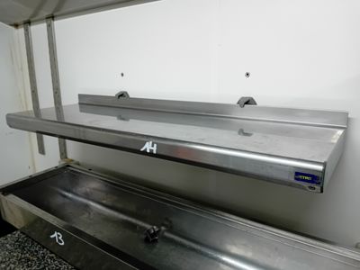 a metal sink in the corner of a kitchen