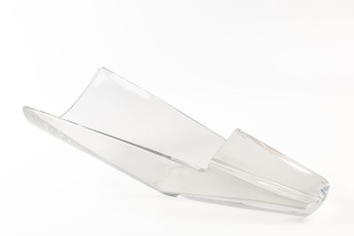 un vase en verre transparent posé sur une surface blanche