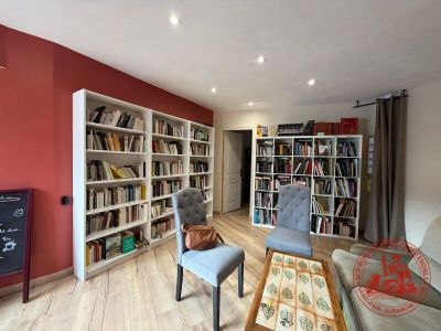 un salon équipé d'un canapé, d'un fauteuil et d'une bibliothèque