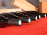 several bottles of wine are lined up on a red table