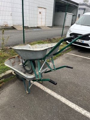 une brouette sur un parking, à côté d'une voiture