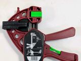 a red and black pipe cutter with a green handle
