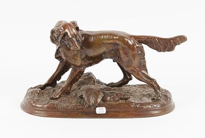 bronze statue of a dog on a rock on a white background
