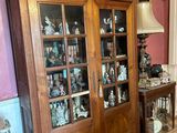 a large wooden cabinet with glass doors in a room